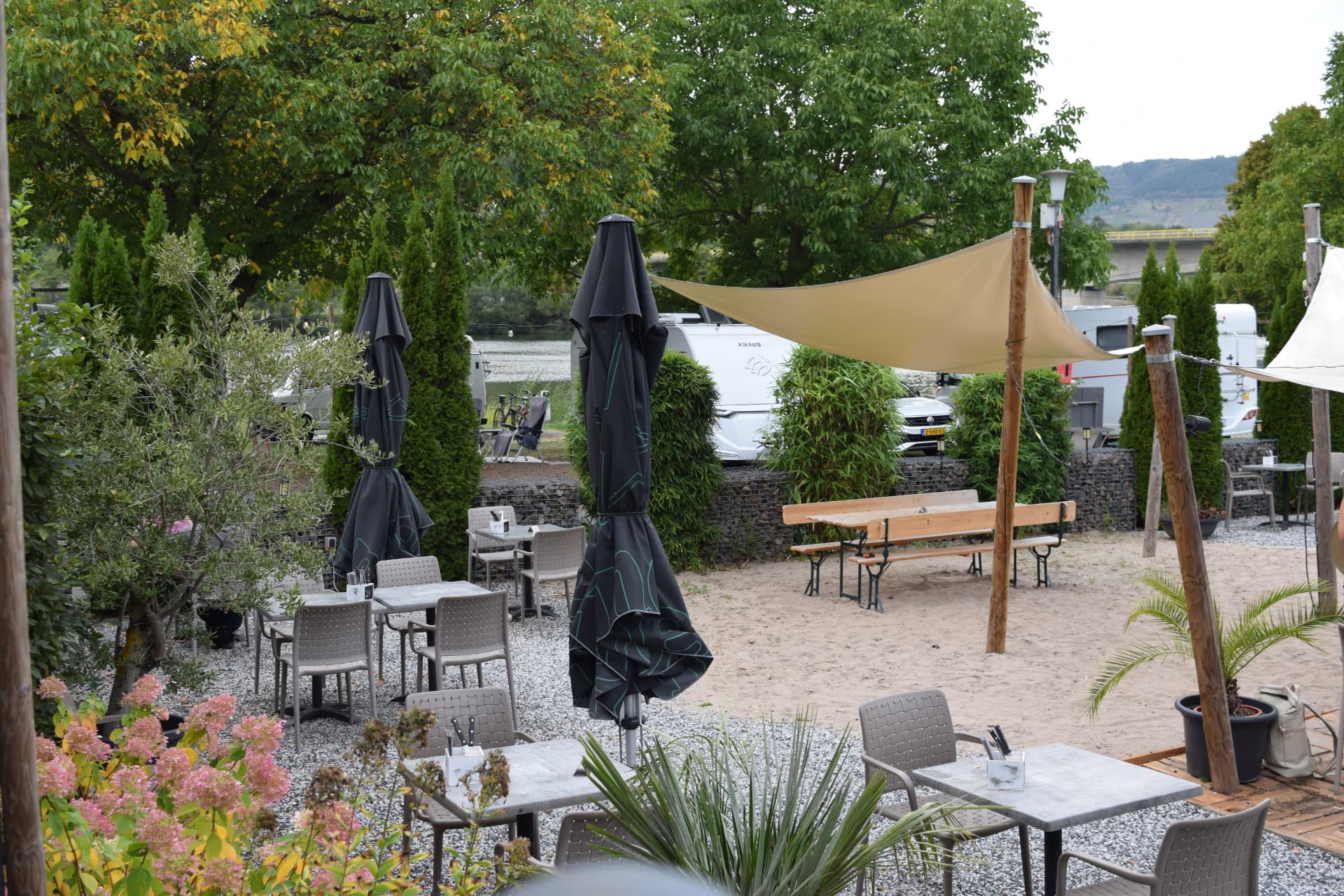 Sonnenterrasse des Riff Schnitzel & Burgerhouse mit Tischen und Schirmen